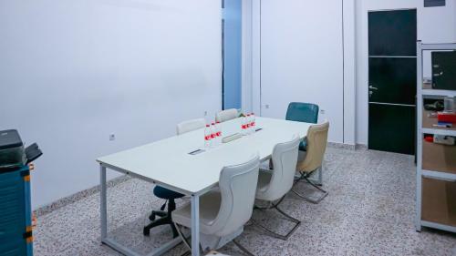 a conference room with a white table and chairs at Collection O Tunas Plaza Residence in Bekasi