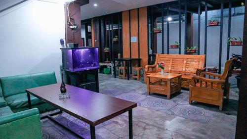 a living room with a couch and a table and a stove at Collection O Tunas Plaza Residence in Bekasi