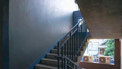 a staircase leading up to a building with blue walls at Collection O Tunas Plaza Residence in Bekasi