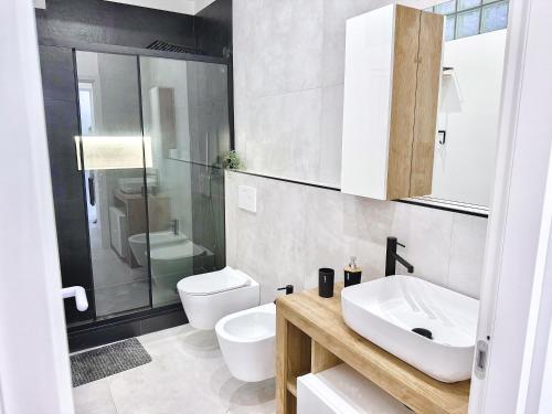 ein weißes Badezimmer mit Waschbecken und Toilette in der Unterkunft Casa A'mar in Giardini-Naxos