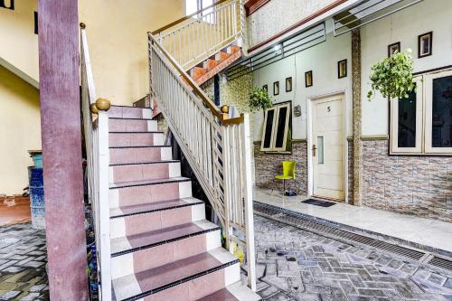 a staircase in a house with a brick wall at OYO 91795 Kos Jeehel Syariah in Sidoarjo