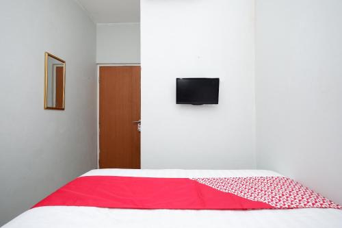 a bedroom with a bed with a red blanket at Hotel O Palebon Residence in Semarang