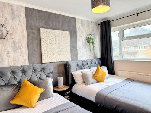 a bedroom with two beds with yellow pillows at Spacious 4BedNear Nottingham Derby Sleeps 8 in Long Eaton