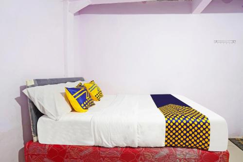 a bed with colorful pillows on it in a room at Hotel O Biring Residence in Cimahi
