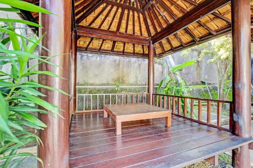 a wooden gazebo with a bench on a deck at Hotel O Orchid Guest House in Yogyakarta