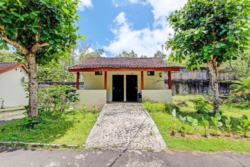 a small house with a door in a yard at Hotel O Orchid Guest House in Yogyakarta