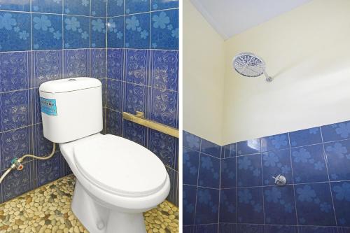 a bathroom with a toilet and a blue tiled wall at Hotel O Putih Mulia Homestay Syariah in Lumajang