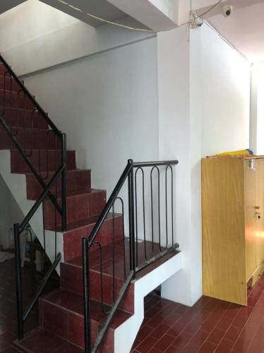 a staircase in a room with red bricks and white walls at Hotel O Rumah Oma Syariah in Kupang