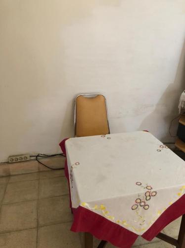 a table and a chair with a table cloth on it at Hotel O Rumah Oma Syariah in Kupang