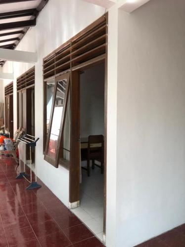 a room with a wall with a door and a table at Hotel O Rumah Oma Syariah in Kupang