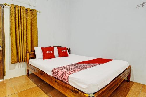 a bedroom with a bed with red pillows on it at OYO Life 92253 Nova Homestay in Kalak