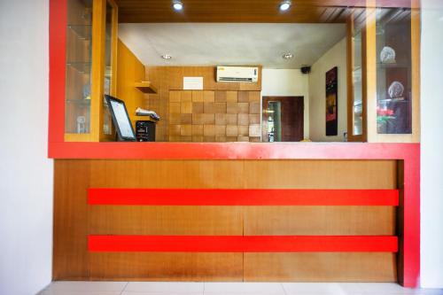 a fast food counter in a restaurant with a red stripe at Hotel O Wisma Kuta Karang in Lhokseumawe
