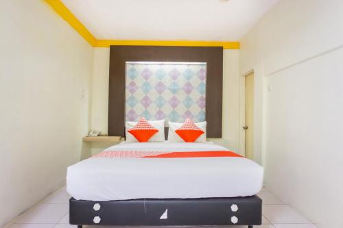 a large bed in a room with a window at Hotel O Wisma Kuta Karang in Lhokseumawe
