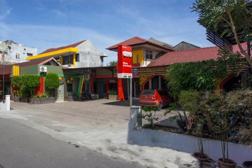 a street with houses and a car parked in front at Hotel O Wisma Kuta Karang in Lhokseumawe