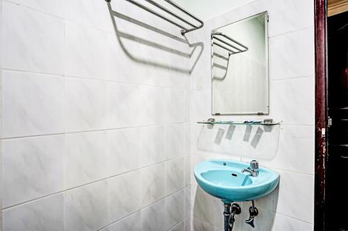 a bathroom with a blue sink and a mirror at Hotel O Wisma Bari in Palembang