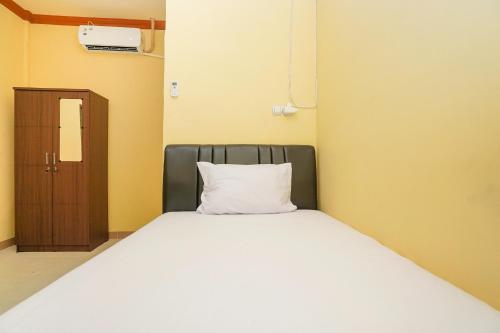 a bed with a white pillow in a room at OYO Life 2619 Kost Keluarga Cemara in Gresik