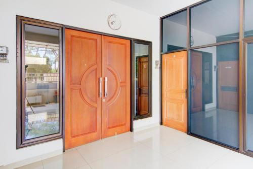 a pair of wooden doors in a room with windows at OYO Life 89990 Kost Waterfront 75 Sub in Surabaya