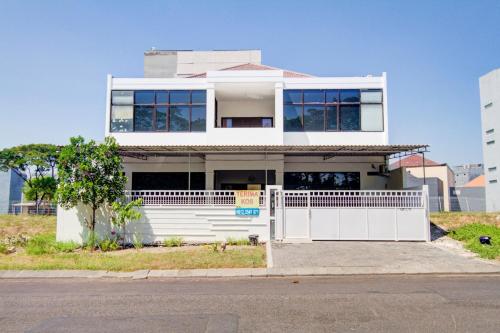 a white house with a fence in front of it at OYO Life 89990 Kost Waterfront 75 Sub in Surabaya
