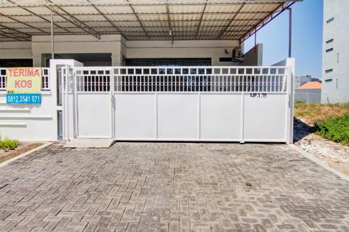 a white gate in front of a house at OYO Life 89990 Kost Waterfront 75 Sub in Surabaya