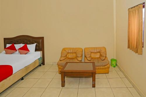 a bedroom with a bed and a table and a chair at Hotel O Danau Indah in Bekasi