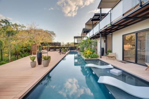 an outdoor swimming pool with a deck and a house at The Bungalows #6 - Boutique Hotel in Flamingo Beach - Top Level Studio in Playa Flamingo