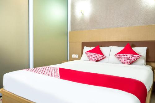 ein Schlafzimmer mit einem Bett mit roten und weißen Kissen in der Unterkunft Capital O 664 Romance Hotel in Nagoya