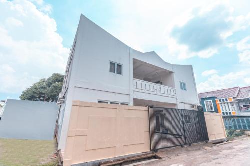 a white building with a gate in front of it at OYO Life 2658 Kost Rasyamada in Bogor