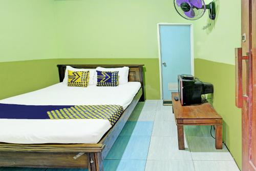 a bedroom with a bed and a television in it at OYO Life 92264 Argo Homestay in Kalak