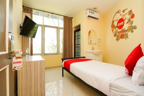 a hotel room with a bed and a television at Capital O 175 K-60 Residence in Surabaya