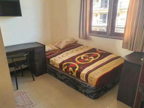a small bedroom with a bed and a desk at OYO Life 93202 Pentagon Homestay Syariah in Surabaya