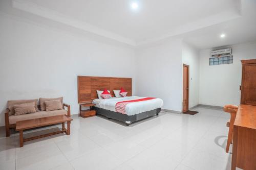 a bedroom with a bed and a couch at Hotel O Bunga Karang Hotel in Bekasi