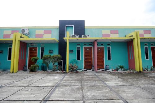 a building with blue and yellow at Hotel O Wisma Ria in Lubuklinggau