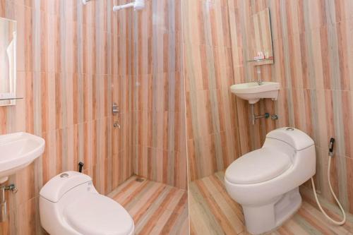 a bathroom with a white toilet and a sink at Capital O 854 Ub Caisar Hotel in Banda Aceh