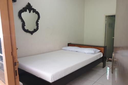 two beds in a room with a mirror on the wall at OYO Life 2090 Ratna Backpacker Syariah in Probolinggo