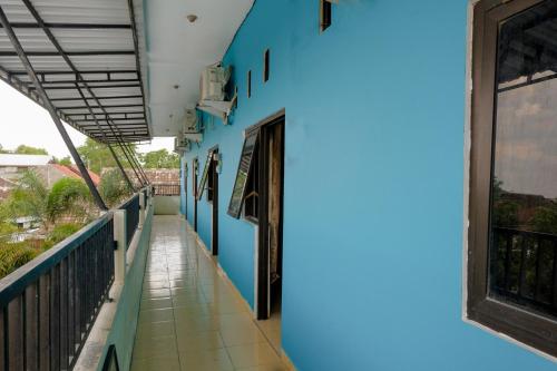 a building with blue walls and a balcony at OYO 1784 Hj. Aniek Residence in Madiun