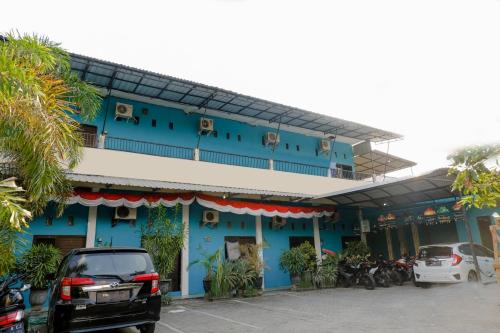 a blue building with cars parked in front of it at OYO 1784 Hj. Aniek Residence in Madiun