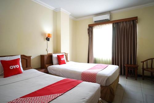 a hotel room with two beds and a window at OYO 2015 Bandara Hotel Balikpapan in Balikpapan