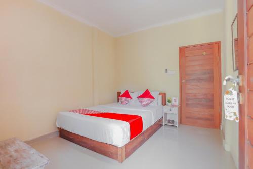 a bedroom with a bed with red pillows on it at OYO Life 90301 Hidden Village Uluwatu in Jimbaran