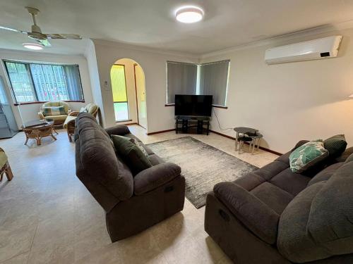 a living room with two couches and a piano at Peel Terrace Escape in Busselton