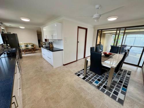 a kitchen and living room with a table and a dining room at Peel Terrace Escape in Busselton