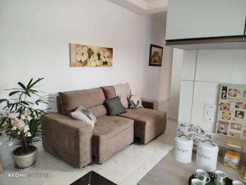 a living room with a brown couch at Apartamento à 3min do Aeroporto in São José dos Pinhais