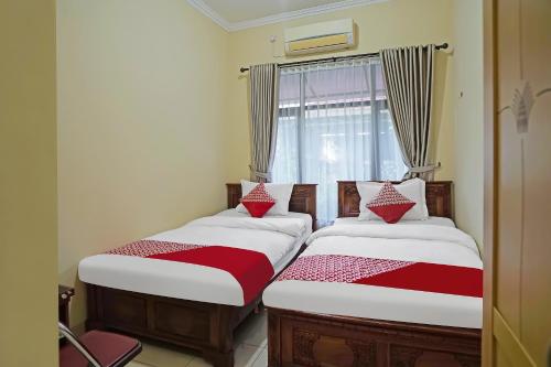 Postel nebo postele na pokoji v ubytování Hotel O Wisma Empat Lima Syariah