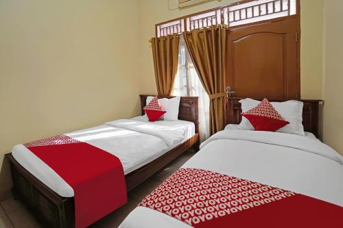 Postel nebo postele na pokoji v ubytování Hotel O Wisma Empat Lima Syariah