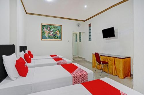 a hotel room with two beds and a television at Hotel O Victory in Batu
