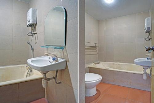 a bathroom with a sink and a toilet and a bath tub at Hotel O Victory in Batu
