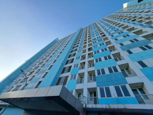 Un edificio alto con un cielo azul al fondo. en OYO Life 93106 Apartement Grand Sentraland By Andi, en Karawang