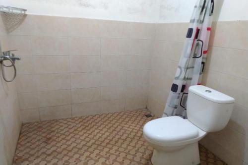 a bathroom with a toilet and a shower at Hotel O Spring Homestay in Jember
