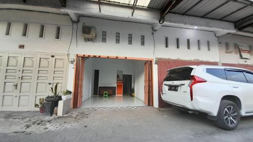 a white car parked in front of a garage at Hotel O Family Homestay Syariah in Medan