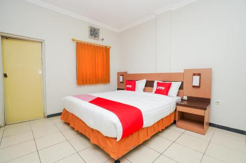 a bedroom with a large bed with red pillows at Hotel O Graha Marina in Surabaya
