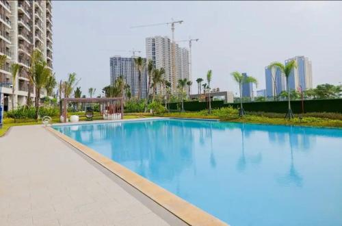 a large blue swimming pool with buildings in the background at Capital O 93529 September House in Samporo
